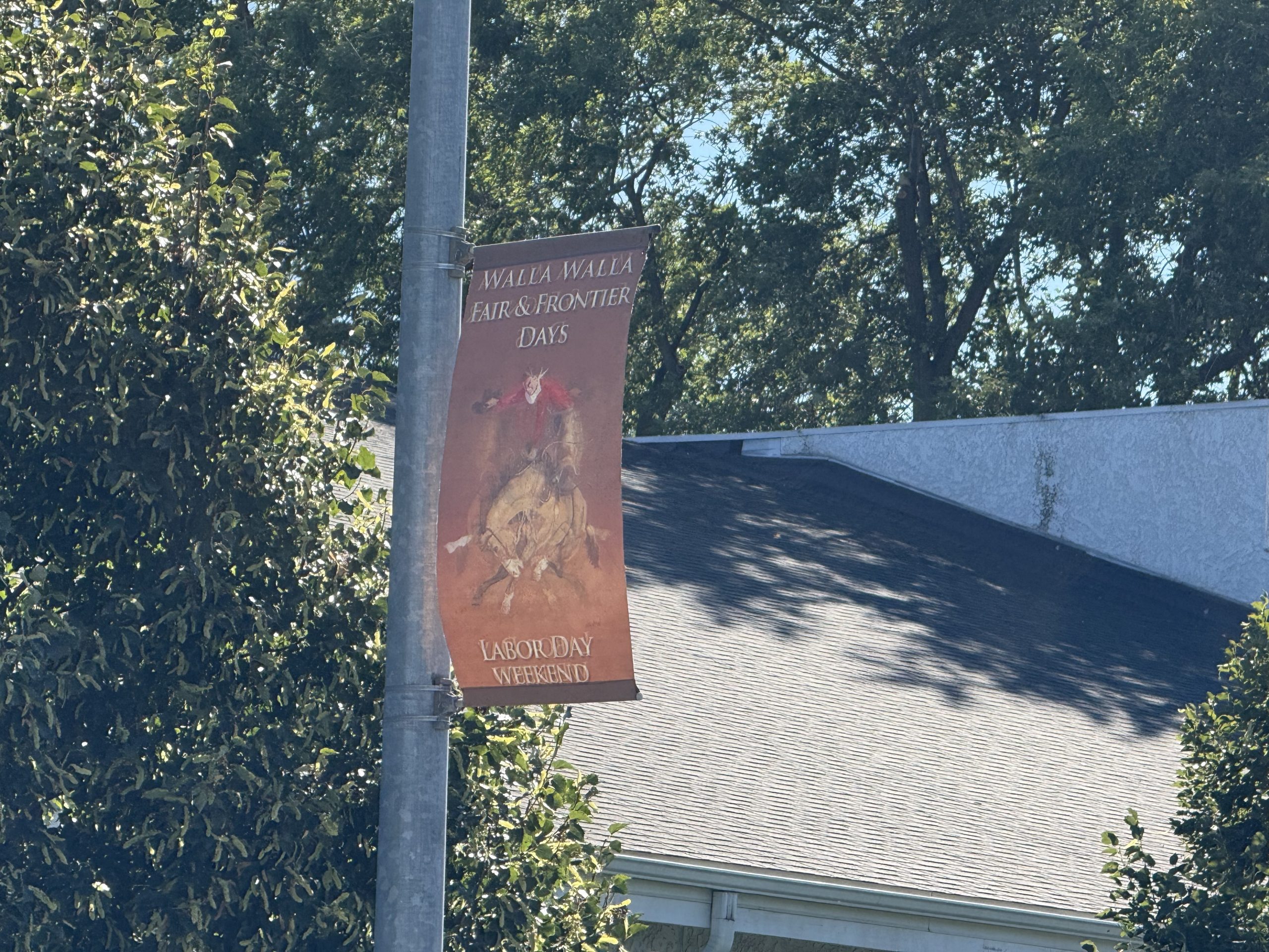 A Walla Walla Fair & Frontier Days lightpost banner for Labor Day Weekend, hung on a downtown street.
